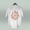 Camiseta blanca unisex con ilustración artística de flores en círculo y la frase inspiradora Eres lo que te repites. Diseño exclusivo creado por ilustrador colombiano, ideal para quienes buscan ropa original con mensajes motivadores. Disponible en tallas varias y con envíos a todo Colombia.