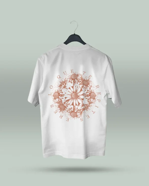 Camiseta blanca unisex con ilustración artística de flores en círculo y la frase inspiradora Eres lo que te repites. Diseño exclusivo creado por ilustrador colombiano, ideal para quienes buscan ropa original con mensajes motivadores. Disponible en tallas varias y con envíos a todo Colombia.