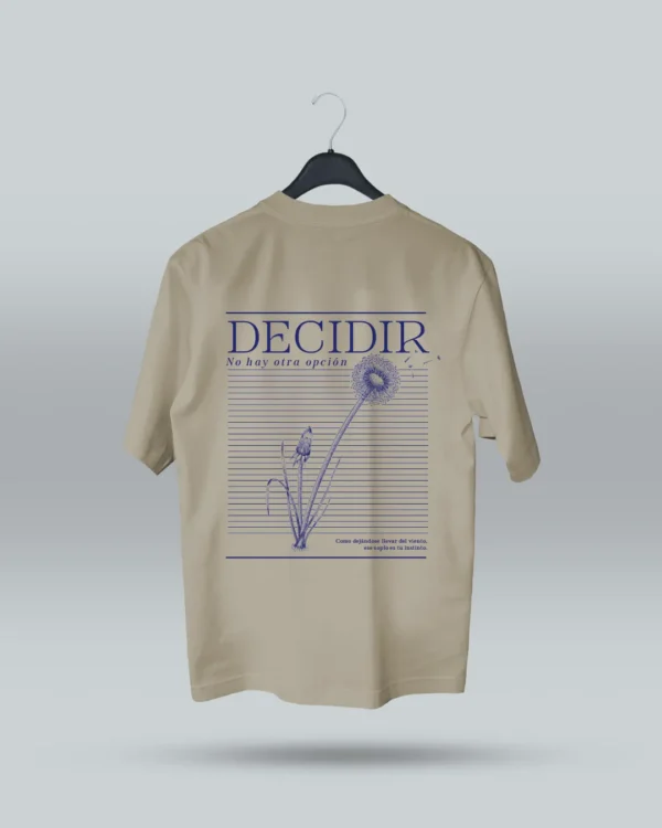 Camiseta beige unisex con ilustración artística de diente de león y frase motivadora Decidir, no hay otra opción. Diseño exclusivo de ilustrador colombiano, ideal para expresar estilo con mensajes inspiradores. Disponible en tallas variadas y con envíos a todo Colombia.