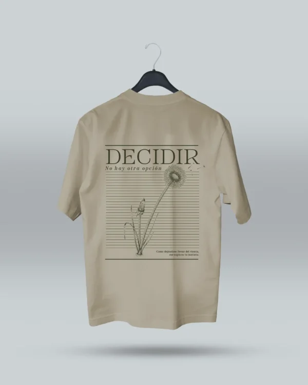 Camiseta beige unisex con ilustración artística de diente de león y frase motivadora Decidir, no hay otra opción. Diseño exclusivo de ilustrador colombiano, ideal para expresar estilo con mensajes inspiradores. Disponible en tallas variadas y con envíos a todo Colombia.